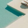 a pool with lounge chairs and a step