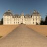 a large white building with a path leading to it with Château de Cheverny in the background